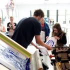 The Print Room director Chris Brun (left) checks out a T-shirt with an image of Albert Einstein...