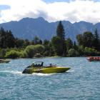 The Thunder Jet boat (right), containing the operator's first group of customers, departs the...