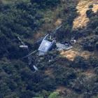 The wreckage of the Royal New Zealand Air Force Iroquois helicopter on the side of a hill in...