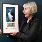 The Yellow-eyed Penguin Trust general manager Sue Murray hopes to auction off this framed new...