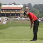 Tiger Woods taps in his par putt on the first hole during the final round of the Bridgestone...