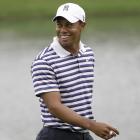 Tiger Woods walks on the eighth green after completing a putt during the Pro-Am competition of...