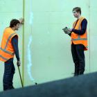 Tim Notman, left and Luke Kenneally assess a  Dunedin retaining wall. Photo by Peter Mcintosh