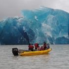 Tourists on a Glacier Explorers' boat get a spectacular view of an iceberg calving from the face...
