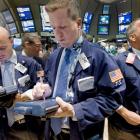 Traders Steven Marcus, Kevin Osowiecki and Albert Young, left to right, work on the floor of the...