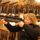 Trixie Scott, of Dunedin, check the sights on a .22 rifle at Allan Millar's Hunting and Fishing...