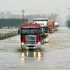 Trucks negotiate a flooded State Highway 1 at Richmond, north of Oamaru, yesterday. Lighter...