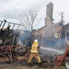 Tuatapere Volunteer Fire Brigade deputy chief fire officer Graeme Egerton dampens down hot spots...