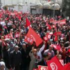 Tunisians wave their national flags during a march against extremism outside Tunis' Bardo Museum....