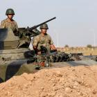 Turkish soldiers stand guard in an armoured personnel carrier on the Turkish-Syrian border near...
