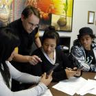 Tutor Timothy Ball (second from left) helps (from left) Faiumu Pavahi, Lisa Lam Cheung and...