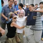 Two activists, centre, of an U.S. religious group are grabbed by security agents in Tiananmen...