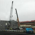 Two cranes lift an 8.5m-long concrete wall panel into place as a twin-level storage building at...