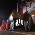 Two police officers talk to a truck driver early on May 20 at a checkpoint at the scene of a...