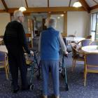 Two residents of Redroofs rest-home walk through the dining room. Photo by Linda Robertson.