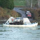 Two utility vehicles are loaded on to the Tuapeka Mouth Ferry yesterday upstream from Clydevale....