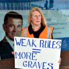 Union member Judith Trevathan, whose uncle died in a workplace accident 13 years ago, protests...