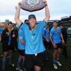 University A captain Brad Cameron lifts the shield after his side won the Dunedin premier club...
