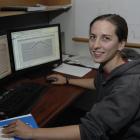 University of Otago geophysics student Joanna Cooper sits beside computer screens displaying...