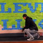 University of Otago student Ollie Wilson (25) adds his details to a student debt art installation...