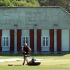 University Oval grounds manager Tom Tamati mows the pitch in front of the former art gallery, a...