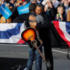 US President Barack Obama (R) hugs singer Bruce Springsteen as he is introduced before he speaks...