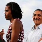 US President Barack Obama smiles while he listens to the first lady, Michelle Obama, introduce...