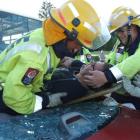 Volunteer firefighters Sam Chapman (left) and Jason Robertson move 'patient' Timothy Storm during...