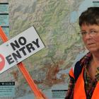 Volunteer Pat Dean with the extra sign she is putting up on Sandfly Bay after a run-in with a...