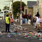 Volunteers make a start on the massive task of cleaning Hyde St after the annual student party....