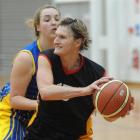 Waikato Wizards centre Carolyn Grey (56) looks for support while marked closely by her Otago...