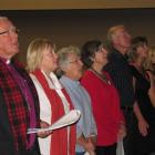 Wakatipu vicar the Rev David Coles sings the national anthem on Friday with other attendees of a...