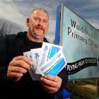 Waldronville School board of trustees chairman Keith Brandish holds fliers aimed at attracting...