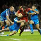 Wales' Jamie Roberts (C) is caught by the Italian defence. REUTERS/Rebecca Naden