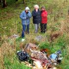 Walkers Jane Cox (left) and Charles and Brenda Tustin observe animal carcasses and rubbish dumped...