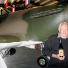 Warbirds Over Wanaka founder Sir Tim Wallis displays a bottle of wine produced to commemorate the...