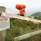 Warning signs and danger tape are installed by Delta worker Gray Townsend at Middle beach, near...