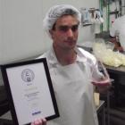 Whitestone Cheese head cheese-maker Chris Moran displays an award for the company's Vintage Blue...