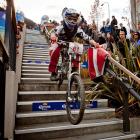 William Parata, of Karitane, bumps down the Brecon St stairs in the Queenstown Bike Festival...