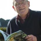 Winston Cooper holds a copy of his book 'Skill and Crossbones: The 125-Year History of the...