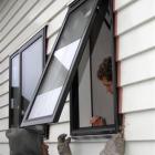 Workers install double glazing in a home taking part in a Beacon Pathway project in the North...
