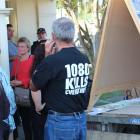 A farmer displays an anti-1080  message on his shirt outside the St John Hall in Lawrence, where...