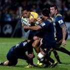 Brumbies first five-eighth Christian Lealiifano is tackled by Highlanders' defenders. Photo:...