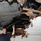 Chris Hope, of Phoenix Services, inspects fire damage in the ceiling of a motel unit at the Tower...