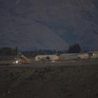 NASA personal lay out the balloon as daylight breaks at Wanaka airport as they make their third...