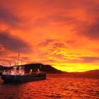 The dredge New Era sails into a red dawn on Otago Harbour. Photo: Stephen Jaquiery