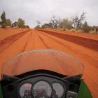 The red dirt of the Australian outback as seen from a motorcycle. Photo by Jenny Longstaff.