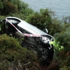 A vehicle sits on its side in scrub after sliding off the road at the Devil's Staircase earlier...