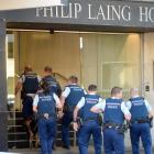 Armed police and a police dog enter the Philip Laing Building on Rattray St after a man carrying...