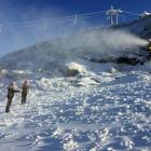 Coronet Peak snow-making team members Jake Reilly (left) and Lucy Ruck measure the snow on the...